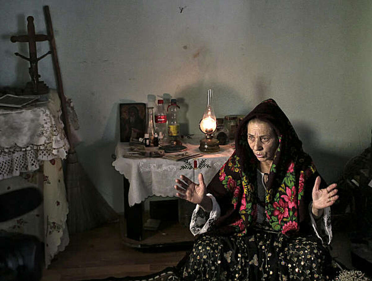 Romanian Bratara Buzea, 63, who was imprisoned for witchcraft under communist dictator Nicolae Ceausescu's repressive regime, speaks during an interview with The Associated Press in Mogosoaia, Romania, Wednesday, Jan. 5, 2011. Trouble is brewing for Romania's witches, whose toil is being taxed for the first time despite their threats of putting curses on the government. Also being taxed for the first time are fortune tellers, who probably saw this coming.