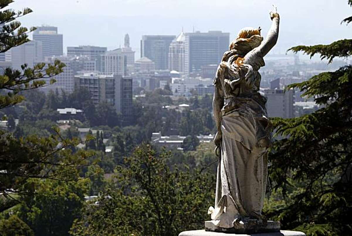 Angel - 1:20 p.m. - Oakland. While driving through Oakland's Mountain View Cemetery trying to take a deer photo, I had to stop and make this image of an angel perched above a family plot with the city skyline as a background. What a peaceful setting. Camera settings: Canon 5D MkII, ISO 200, 1/250, f13, 200mm