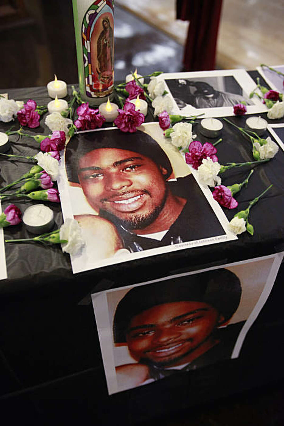 Flowers and pictures of Oscar Grant are on display in Oakland, Calif., Thursday, July 1, 2010 during a gathering to stop the violence in Oakland. Former San Francisco Bay Area Rapid Transit police officer Johannes Mehserle is on trial in Los Angeles for shooting unarmed black man Oscar Grant on New Year's Day 2009 at a BART station in Oakland.