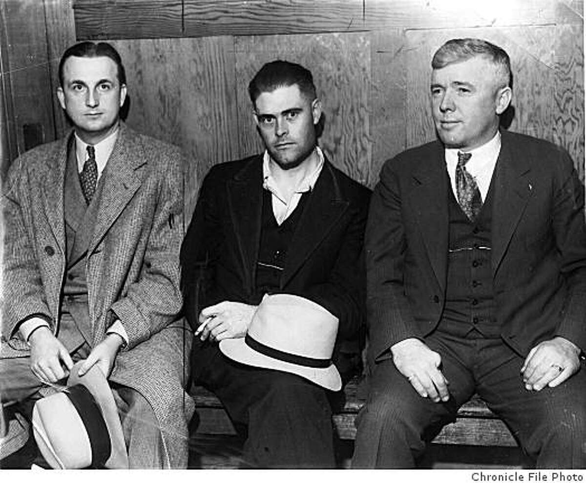 John M. Holmes is seen between Sheriff William Emig (right) and an unknown man.
