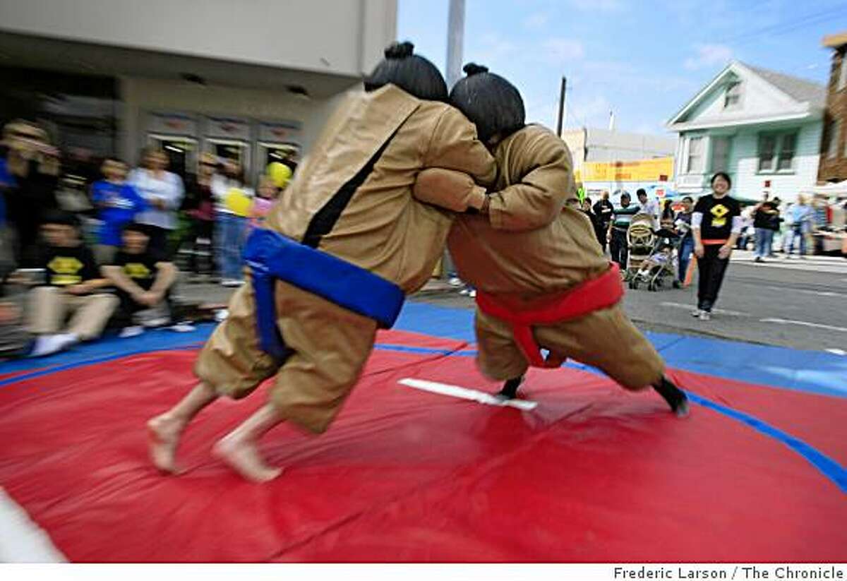 Dennis Bonilla and James Aliberi sumo wrestles each other in a full Japanese dress as both of them get into the spirit of the festivities at the Excelsoir Street Fair in San Francisco, Calif., on October 5, 2008.