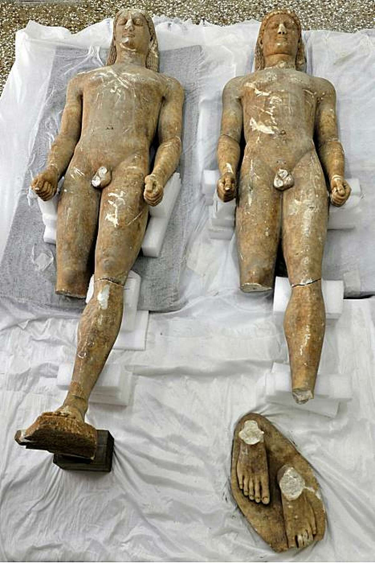 'Kouros' marble male statues dated from the 6th century BC are presented to the media at a workshop at the Archaeological museum of Athens on May 18, 2010. The two statues were found by police in the hands of illegal antique dealers in the area of Corinthon May 14.