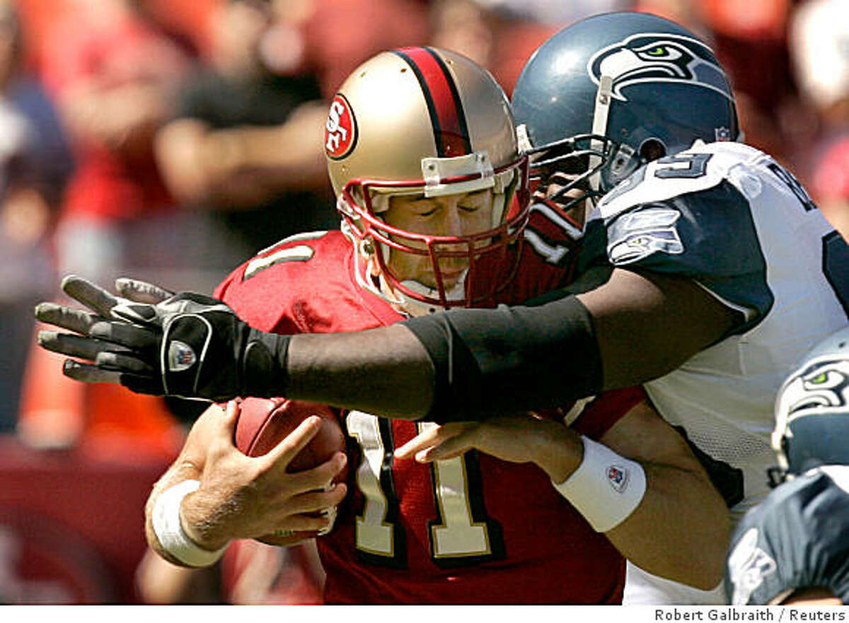 Seattle Seahawks defensive tackle Rocky Bernard (R) sacks San Francisco 49ers quarterback Alex Smith in the first quarter of their NFL football game in San Francisco, California September 30, 2007. Bernard's hit knocked Smith out of the game. REUTERS/Robert Galbraith (UNITED STATES) Ran on: 10-01-2007