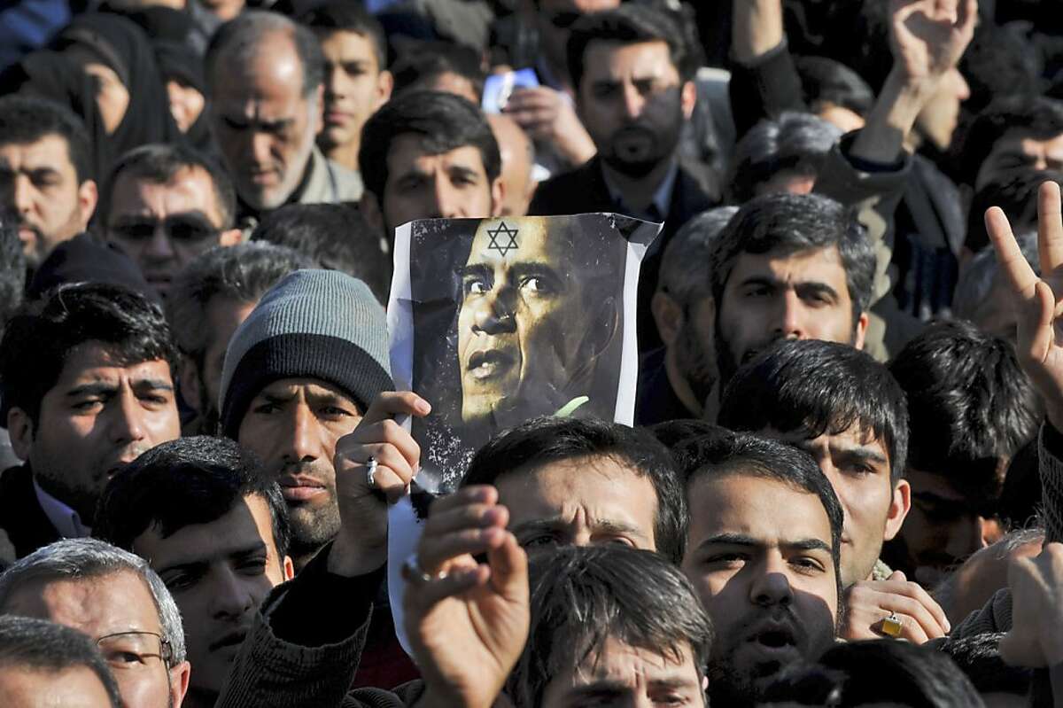 A poster against US President Barack Obama is held during a funeral ceremony of Mostafa Ahmadi Roshan, on Friday, Jan. 13, 2012, a chemistry expert and a director of the Natanz uranium enrichment facility in central Iran, who was killed in a brazen daylight assassination when two assailants on a motorcycle attached a magnetic bomb to his car Wednesday in Tehran. Thousands of mourners chanted "Death to Israel" and "Death to America" on Friday during the funeral of a slain nuclear expert whom Iranian officials accuse the two nations of killing in a bomb blast this week as part of a secret operation to stop Iran's nuclear program. (AP Photo/Iranian Students News Agency, Mehdi Ghasemi)