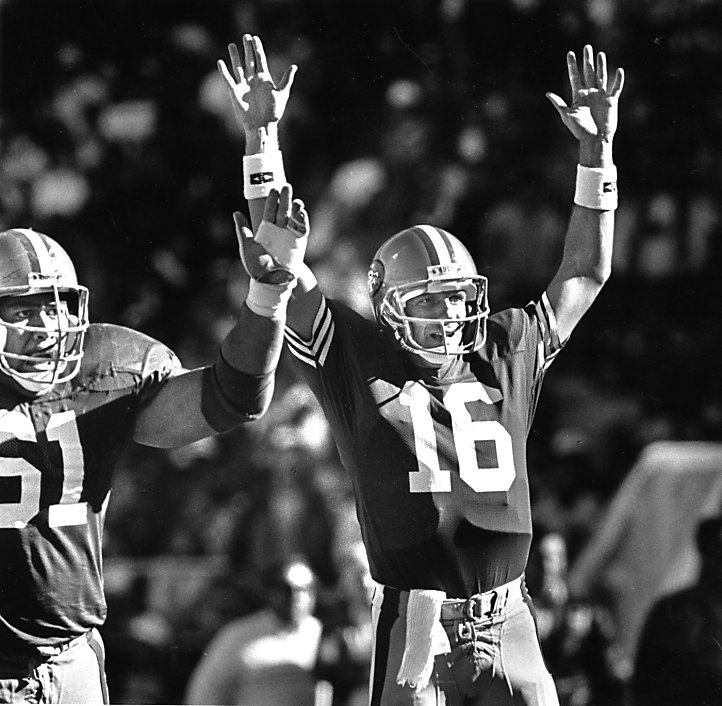 San Francisco 49ers quarterback Joe Montana (R) and Steve Young speak to  each other while wide receiver Jerry Rice (C) holds the 1989 Super Bowl  trophy after an audience of nearly ten