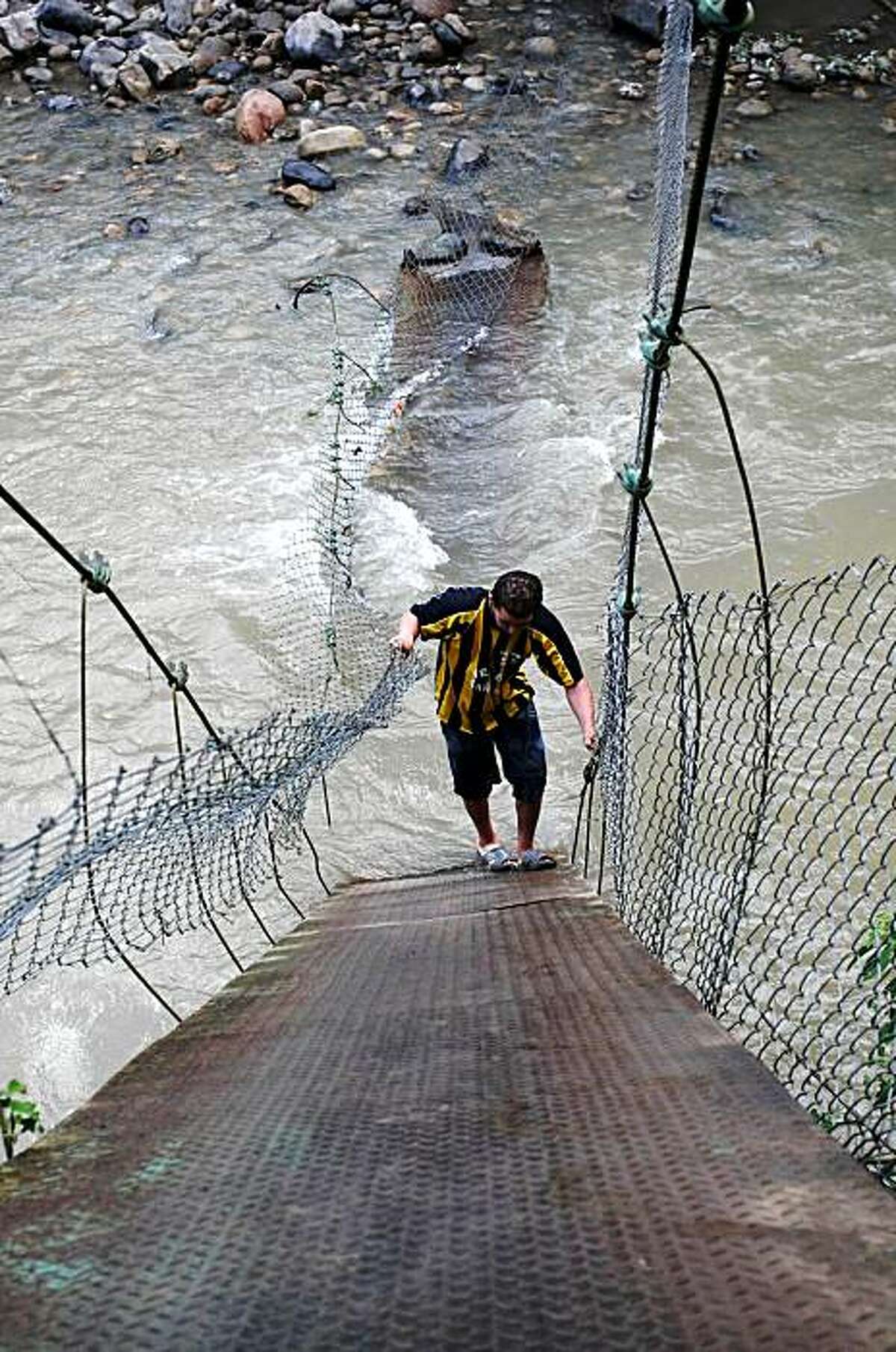 A man climbs a fallen footbridge that links Colombia and Venezuela over the Tachira River in Ragonvalia in northeastern Colombia, Friday, Nov. 20, 2009. Venezuelan Vice President Ramon Carrizales said Venezuelan soldiers destroyed two make shift bridges along its border with Colombia on Nov. 19 because they were being used by drug traffickers.