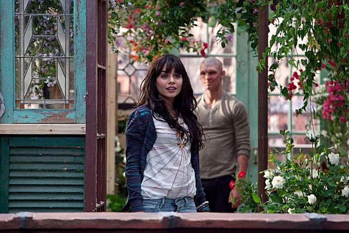 In this film publicity image released by CBS Films, Alex Pettyfer, background, and Vanessa Hudgens is shown in a scene from "Beastly."