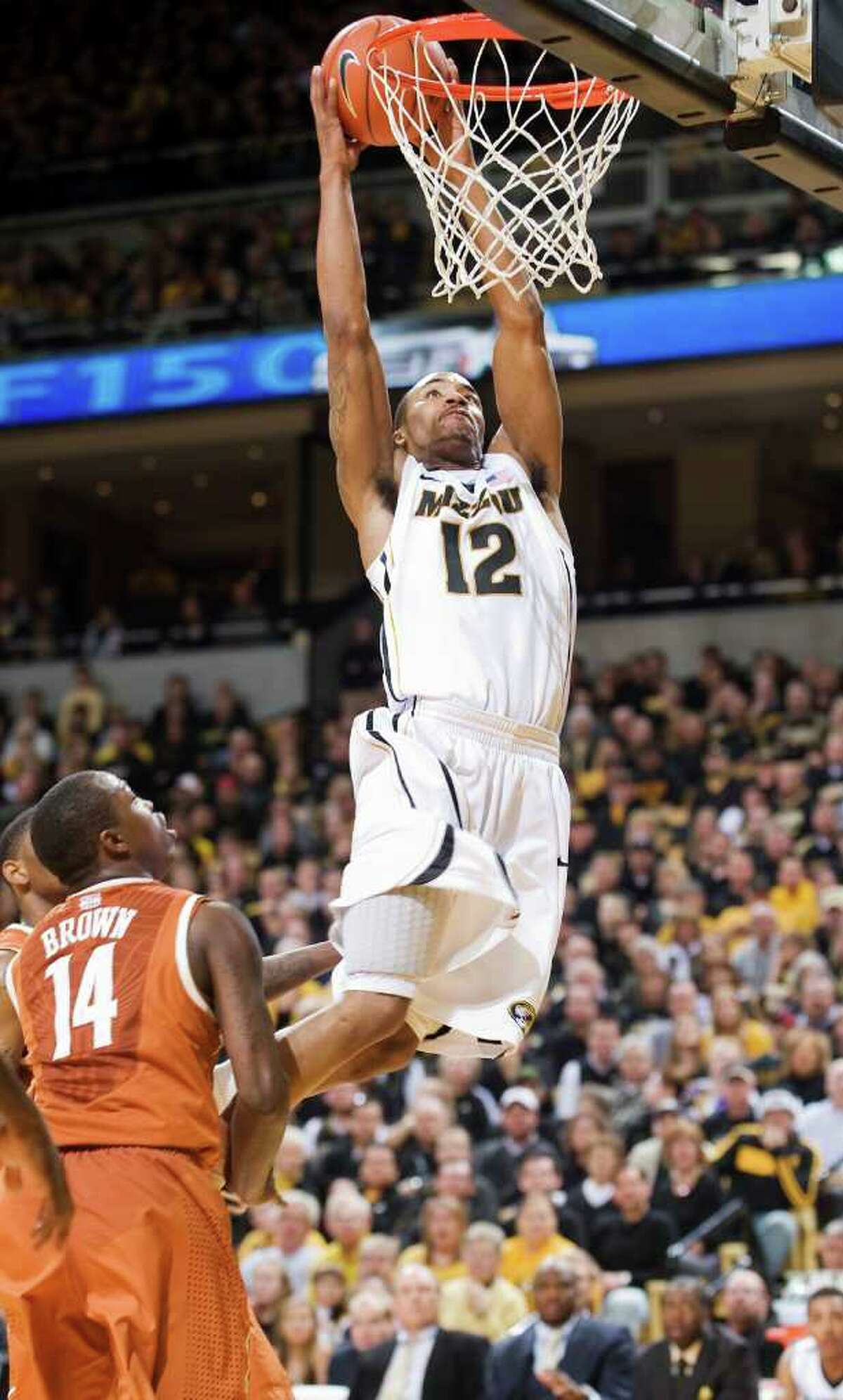 Missouri’s Marcus Denmon dunks as Texas’ J’Covan Brown can only watch. Denmon had 18 points and 11 rebounds in the Tigers’ victory, while Brown’s 34 points went for naught.