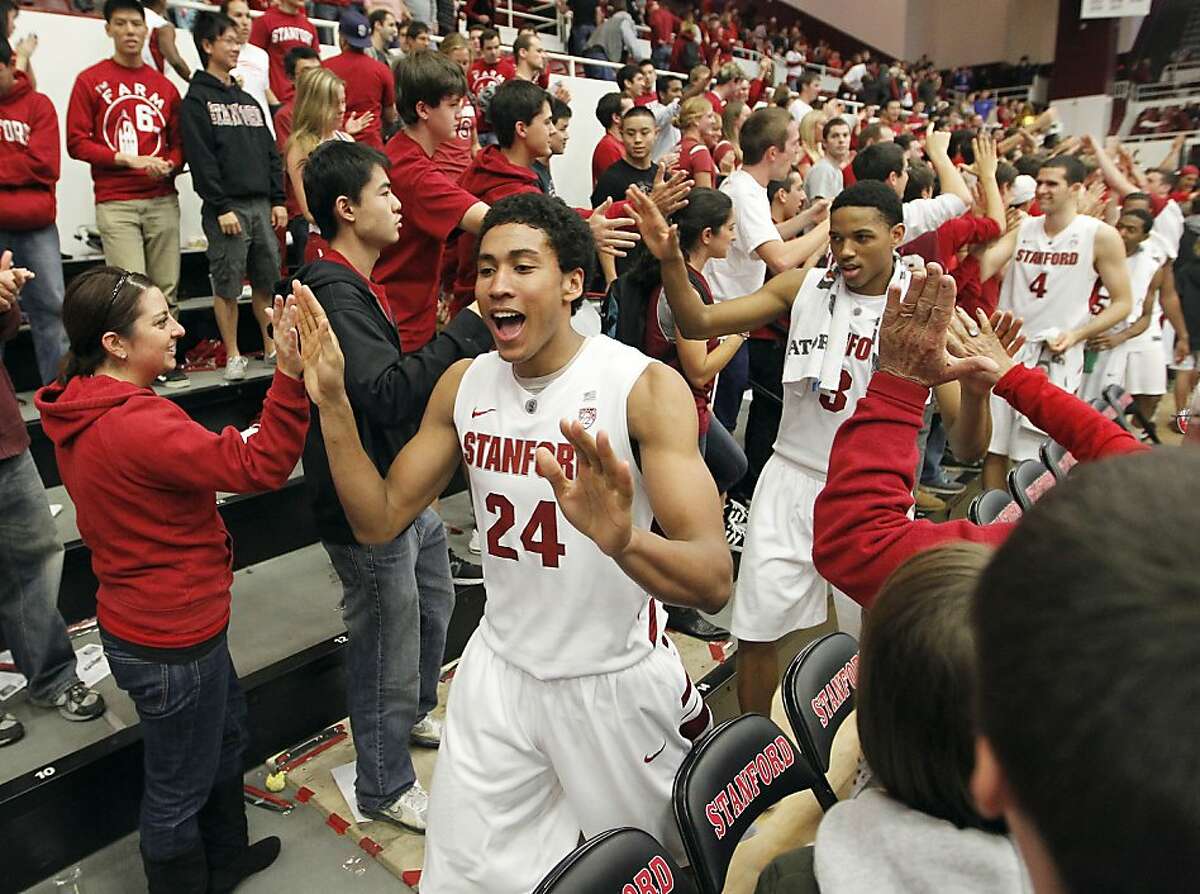 Stanford's Josh Huestis (24), Anthony Brown (3) and teammates celebrates with fans after an 84-64 victory over Colorado in a NCAA college basketball game on Saturday, Jan. 14, 2012, in Stanford, Calif. (AP Photo/Tony Avelar)