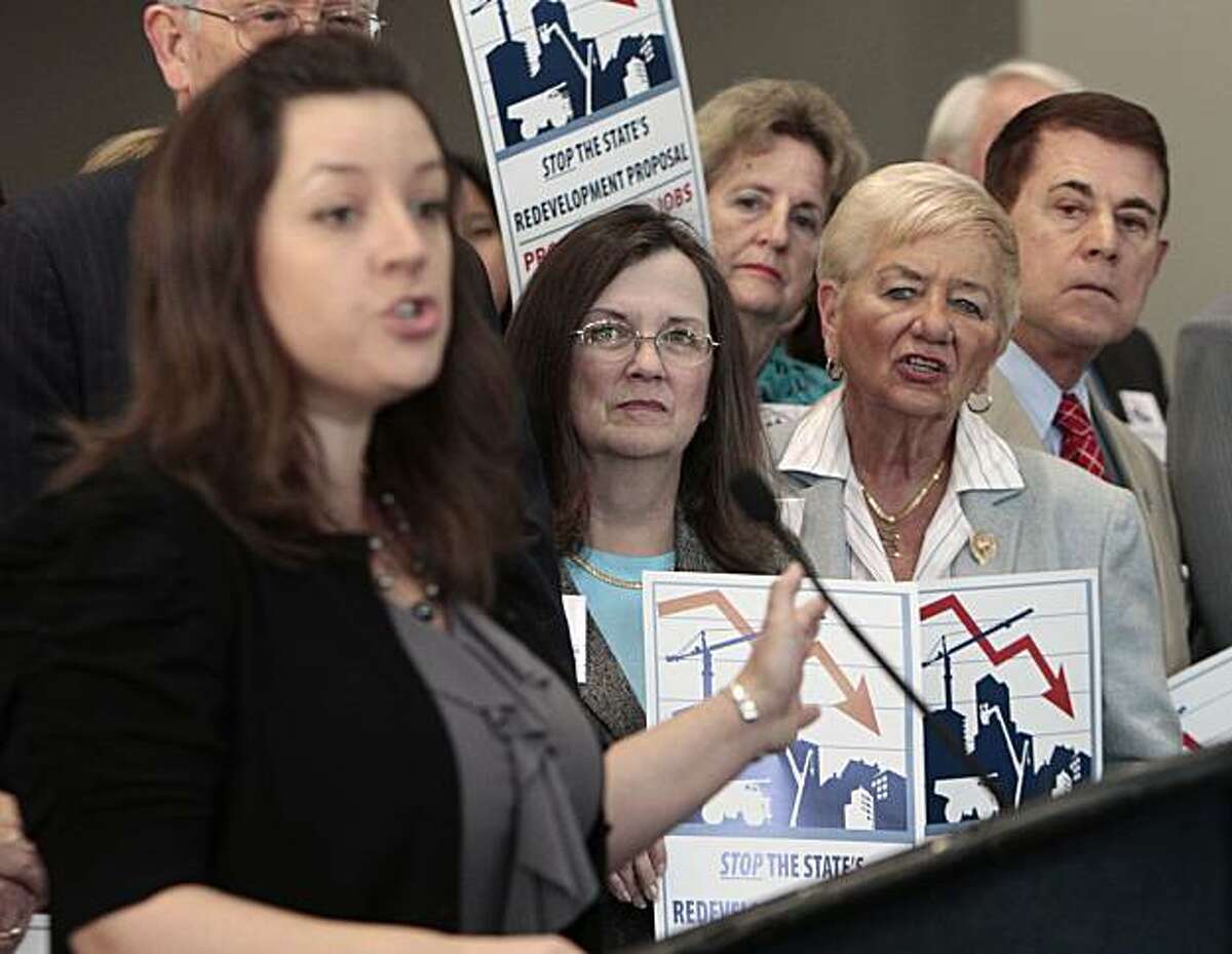 Judy Pierce, a member of the Clayton City Council, second from left, and Canyon Lake City Council member Mary Craton, third from left, listen to Sacramento City Council member Angelique Ashby, left, voice her opposition Gov. Jerry Brown's proposal to eliminate redevlopment agencies, at a news conference in Sacramento, Calif., Friday, Jan. 21, 2011. More than 100 local mayors and city council members from around California urged Brown to drop his plan to eliminate redevelopment agencies saying it producelittle in budget relief and could cause the loss of thousands of jobs statewide.