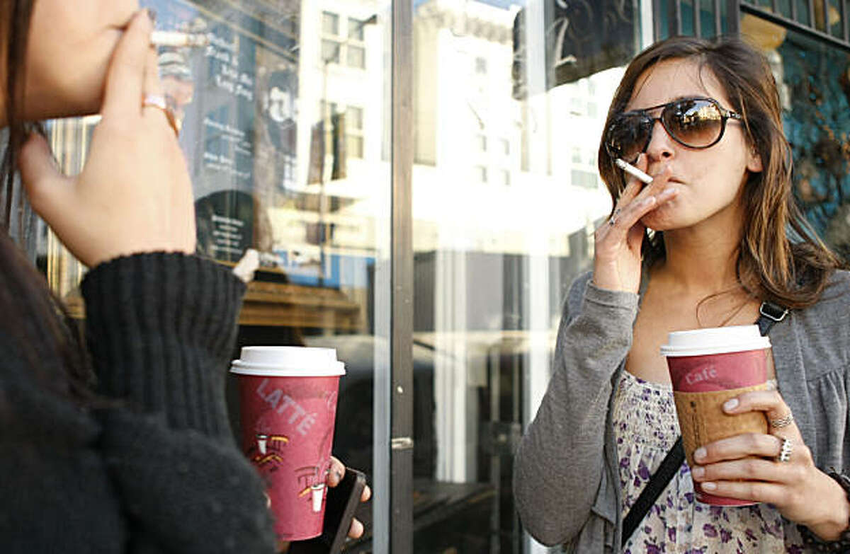 UCSF student Deena Tailo takes a cigarette and coffee break with a friend on upper Haight St. in San Francisco Calif. on Thursday, Jan. 20, 2011.