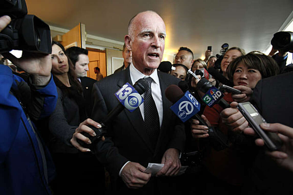 Gov. Jerry Brown talks with reporters after speaking at the League of California Cities conference in Sacramento, Calif., Wednesday, Jan. 19, 2011. Brown told the audience of city officials about his plan to redirect more services back to local government.