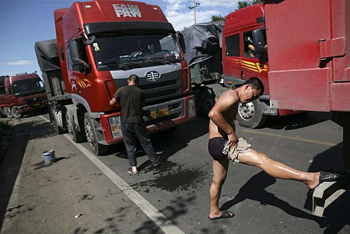 In this photo taken on Monday, Aug. 23, 2010, a truck driver washes himself after waiting over two days in the jam on an entrance ramp to the Beijing-Tibet Highway in Zhangbei county, in north China's Hebei province. The massive traffic jam that stretchesfor dozens of miles and hit its 10-day mark on Tuesday stems from road construction in Beijing that won't be finished until the middle of next month, an official said.