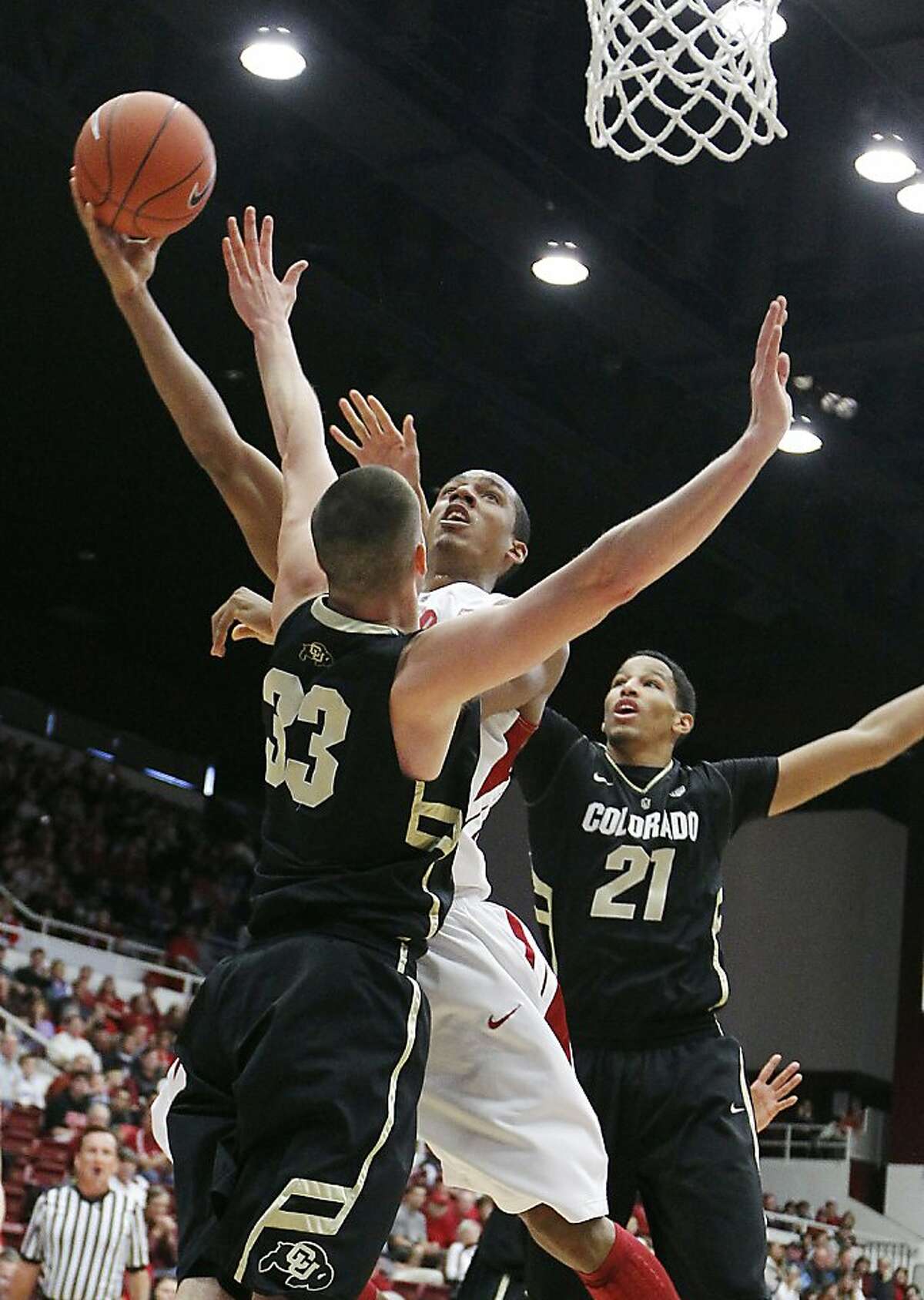 Stanford's Josh Owens, center, shoots over Colorado's Austin Dufault (33) as Andre Roberson (21) looks on in the first half of an NCAA college basketball game on Saturday, Jan. 14, 2012, in Stanford, Calif. (AP Photo/Tony Avelar)