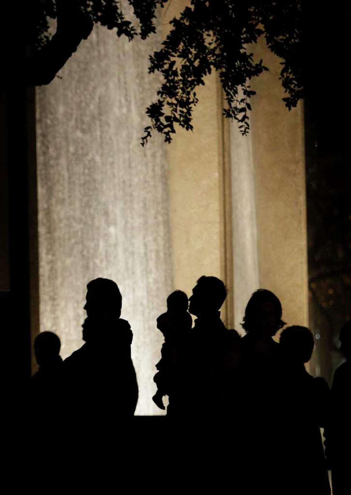 People gather at the Water Wall near the Galleria in vigil for Gelareh Bagherzadeh, who was killed Monday, Jan. 16, 2012, in Houston. The 30-year-old female student at the Texas Medical Center was found shot to death in a car at a residence in the 800 block of Augusta near Sugar Hill near the Galleria early Monday morning.