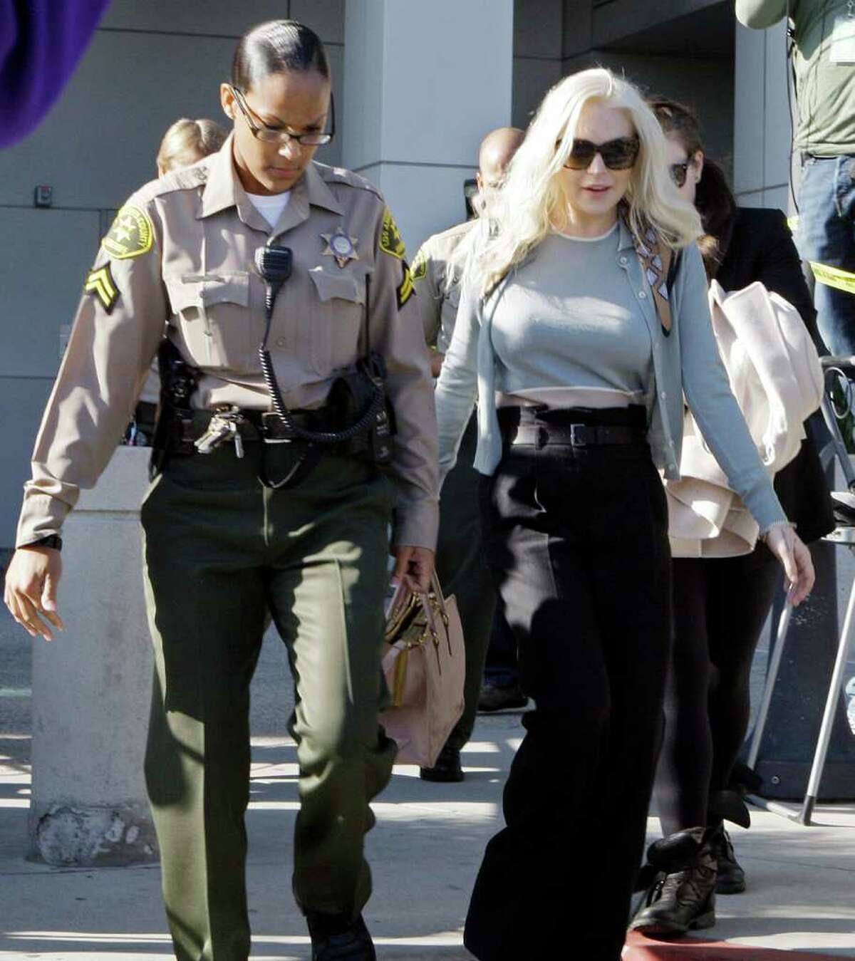 Lindsay Lohan leaves Los Angeles Superior Court after a probation progress hearing Tuesday, Jan. 17, 2012. Superior Court Judge Stephanie Sautner told the actress she is on track to complete strict terms of her probation by the end of March. The 25-year-old is required to do cleanup duty at the morgue and attend therapy sessions. (AP Photo/Reed Saxon)