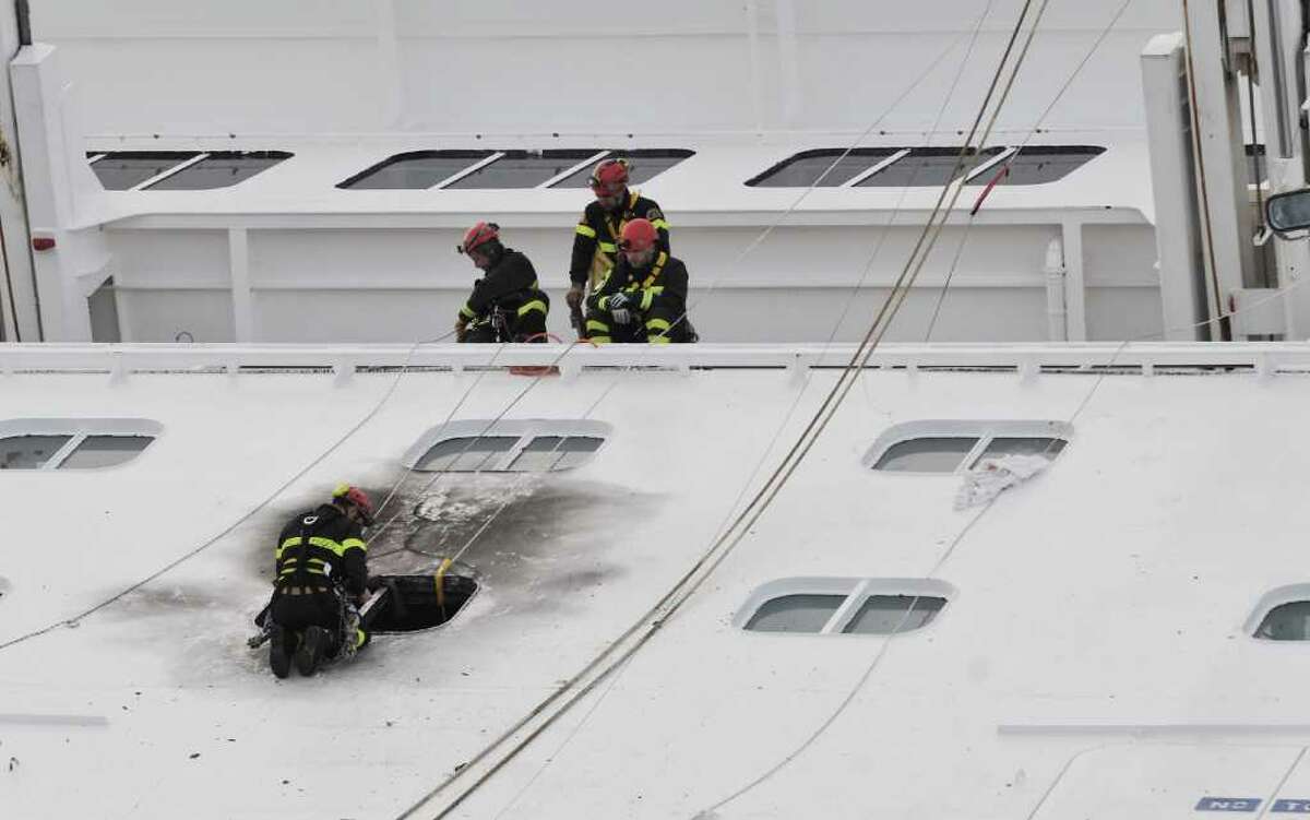 Rescuers on Tuesday work on the cruise ship Costa Concordia as it lies stricken off the shore of the island of Giglio. Five bodies were pulled from the ship.
