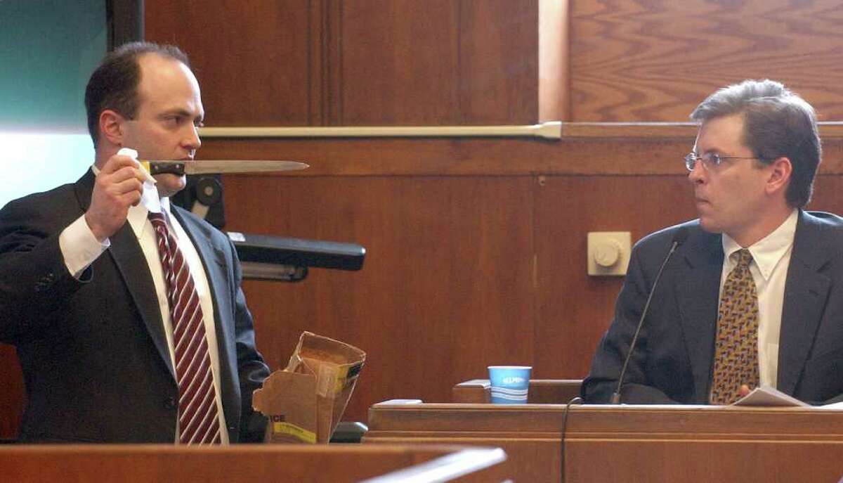 District Attorney Patrick Haggan, left, displays one of the knives allegedly used in the murder lo Nachtwey as Dr. Frank Evangelista, the medical examiner who worked on the case in 2001, testifies during the trial of four men who are charged with the murder of Io Nachtwey Tuesday, April 12, 2005, in Boston. (AP Photo/Ted Fitzgerald, Pool)