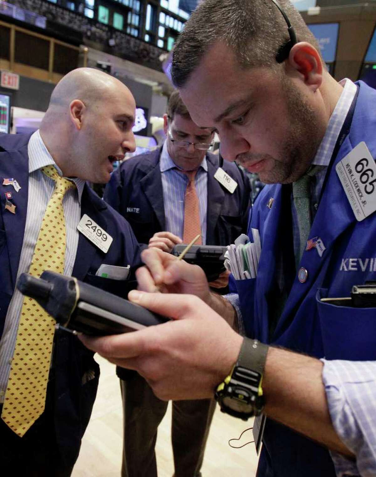 FILE - In this Jan. 10, 2012 file photo, trader Kevin Lodewick, right, works on the floor of the New York Stock Exchange. Robust growth in China helped stock markets rally strongly Tuesday, Jan. 17, 2012, as investor fears of an abrupt slowdown in the world's second-largest economy were eased. (AP Photo/Richard Drew, File)