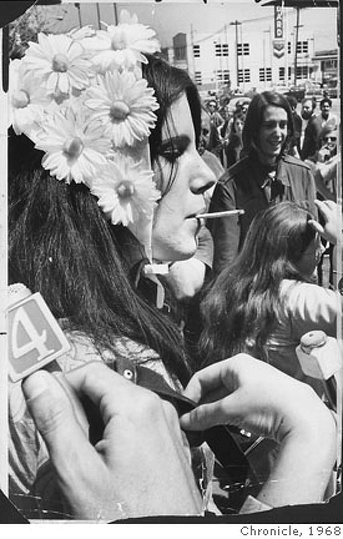 A flower girl named Paula who was wearing a hat of daisies opened a cigarette case. "Anybody want a joint?" she asked. The response was slow, so she tossed a dozen cigarettes into the crowd. Kathy Brady , 18, and Ralph Braun agreed that Bergess is a "wonderful person." Beat Hippies S.F. April 15, 1968