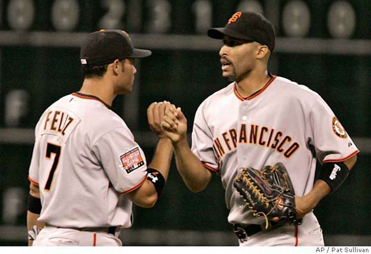 San Francisco Giants Pedro Feliz (7) and Randy Winn celebrate the Giants' 2-1 win in 12 innings against the Houston Astros in a baseball game Thursday, May 17, 2007, in Houston. Feliz scored the winning run on a Winn single that bounced up off first base. (AP Photo/Pat Sullivan)