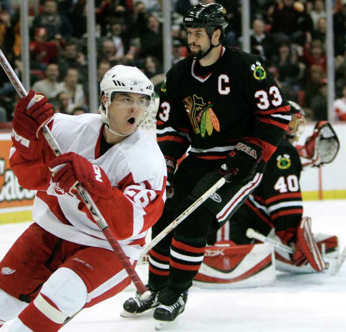 Detroit Red Wings Jiri Hudler , left, of the Czech Republic celebrates his second-period goal as Chicago Blackhawks defenseman Adrian Aucoin (33) skates by goalie Patrick Lalime in an NHL hockey game in Detroit, Friday, March 2, 2007. (AP Photo/Paul Sancya)