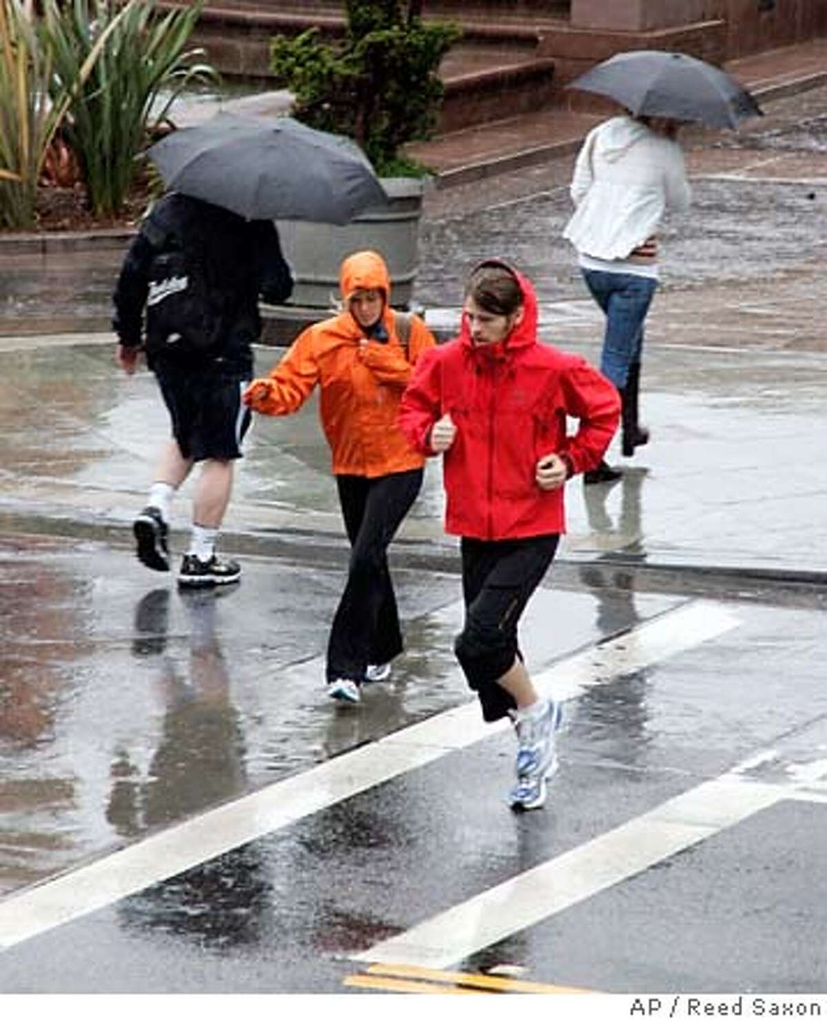 The few pedestrians out and about hurry through rain falling on the Third Street Promenade in Santa Monica, Calif., Friday, April 20, 2007. (AP Photo/Reed Saxon)
