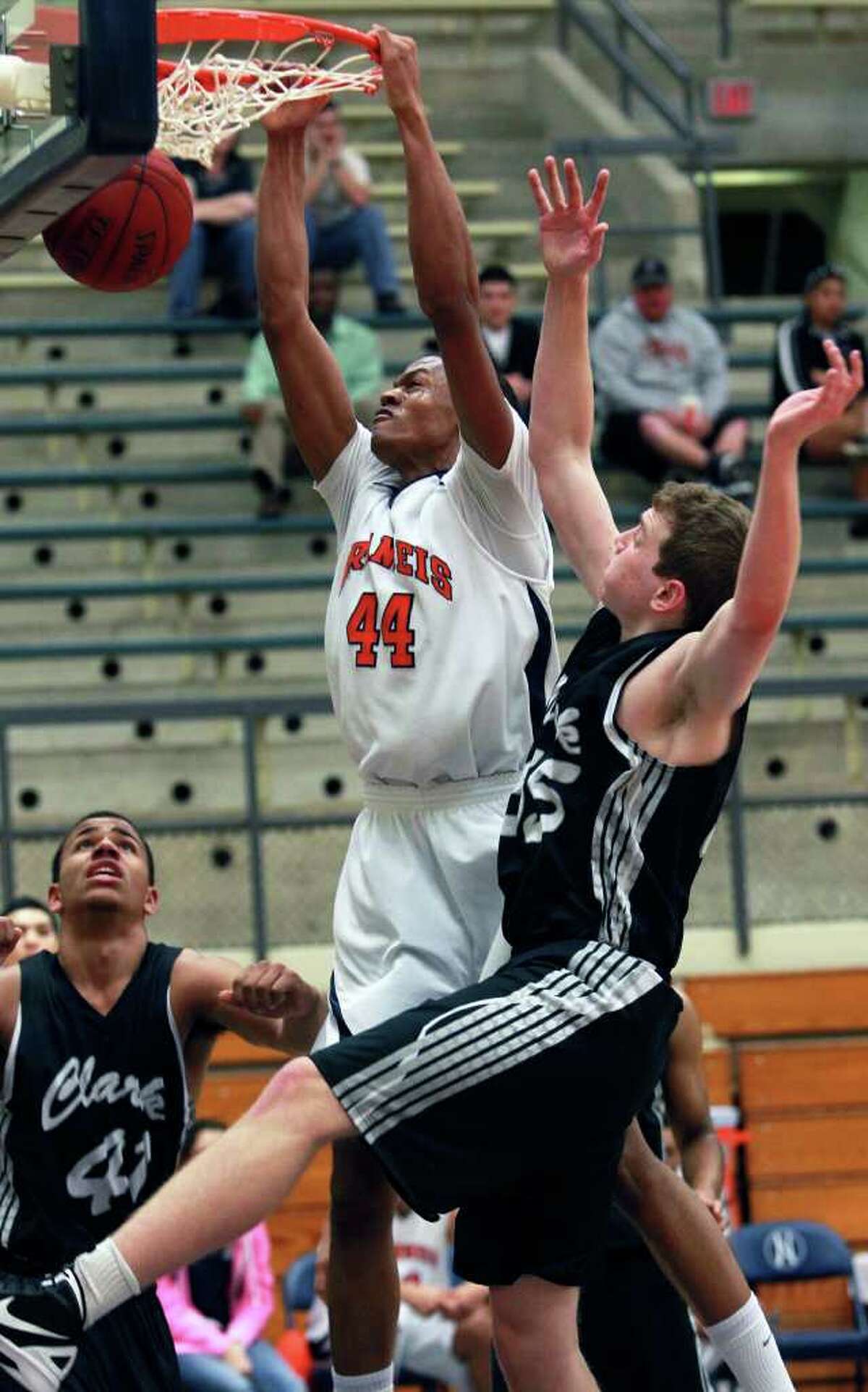 Brandeis post Eric Robinson stuffs a shot against John Chapman (right) and Shawn Gulley as Brandeis plays Clark in boys basketball at Taylor Field House on January 17, 2012 Tom Reel/ San Antonio Express-News
