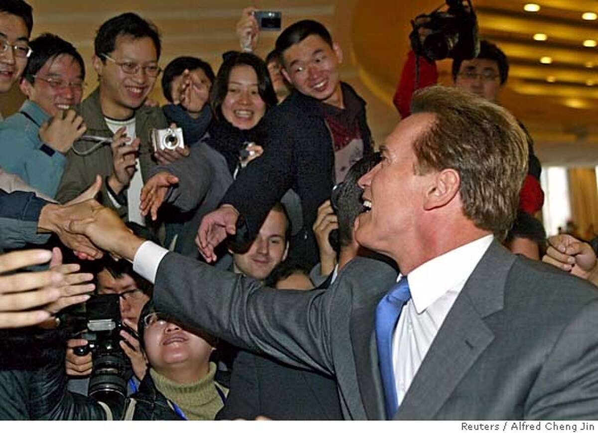California Governor Arnold Schwarzenegger shakes hands with Chinese students after his speech at Tsinghua University in China's capital Beijing November 16, 2005. The Austrian-born actor-turned-politician is leading a trade delegation to China this week, hoping to sell the world's most populous nation everything from oranges to software as well as hammering home his anti-piracy message. REUTERS/Alfred Cheng Jin 0