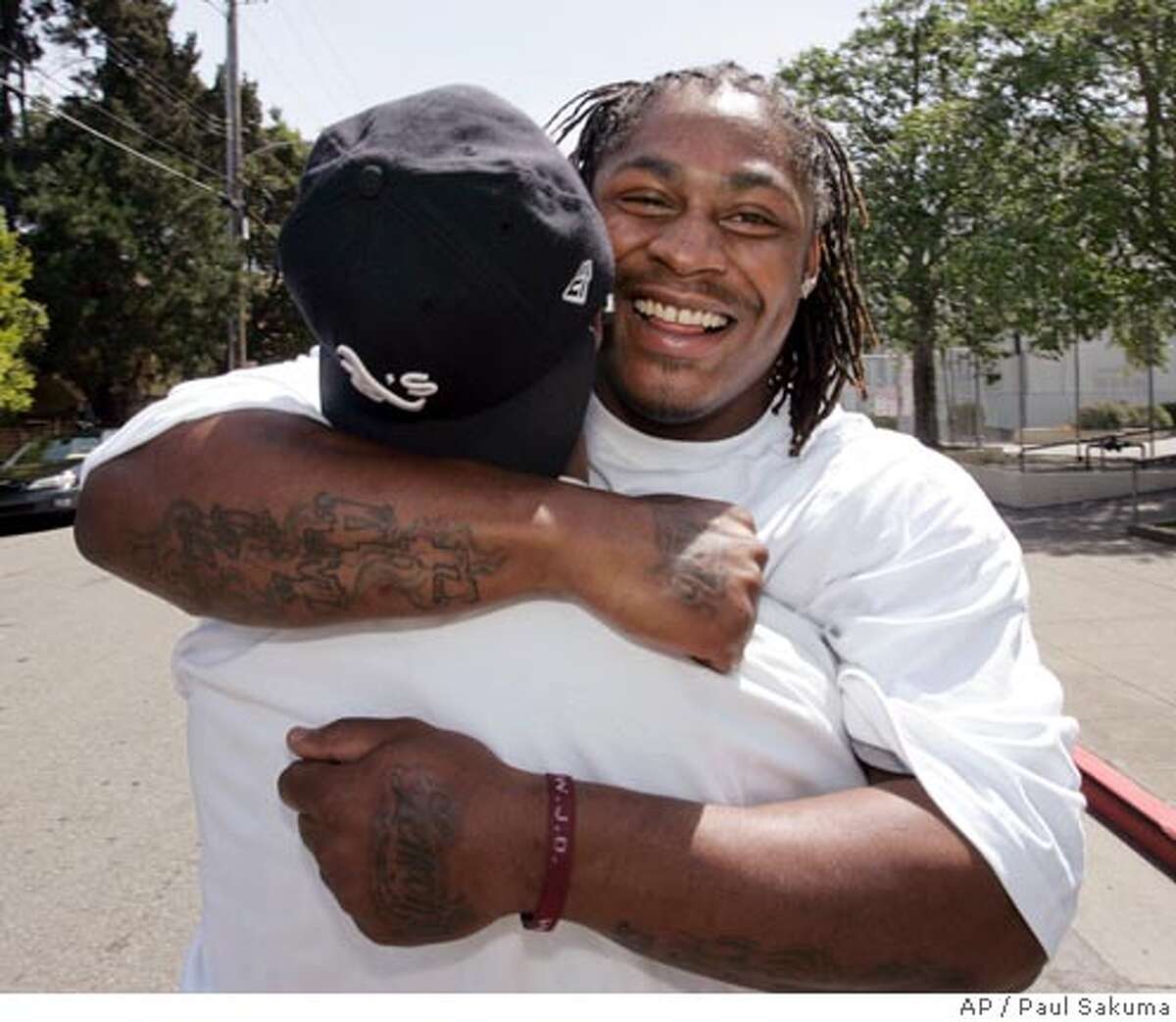 California running back Marshawn Lynch hugs a friend at his former high school, Oakland Technical High School, in Oakland, Calif., Saturday, April 28, 2007, after he was picked by the Buffalo Bills as the No. 12 pick overall in the NFL football draft. (AP Photo/Paul Sakuma)
