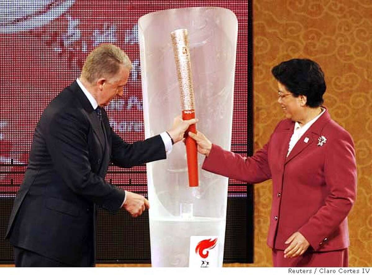 IOC Coordination Commission Chairman Hein Verbruggen (L) and Chinese State Councillor Chen Zhili hold the Beijing Olympic Torch during its unveiling in Beijing April 26, 2007. Beijing announced the 2008 Olympic torch relay route and unveiled the Olympic torch on Thursday in China's capital. REUTERS/Claro Cortes IV (CHINA) 0