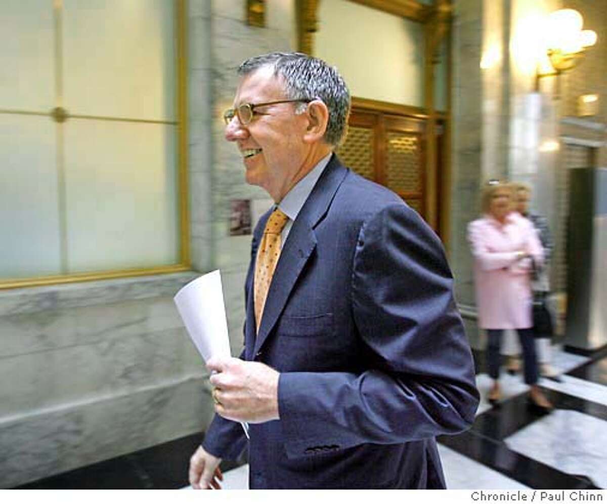 Clint Reilly holds a copy of the agreement as he walks through the lobby of the Merchants exchange building to announce a settlement in his lawsuit against the Hearst Corporation and Media News Group at a news conference in San Francisco, Calif. on Wednesday, April 25, 2007. PAUL CHINN/The Chronicle **Clint Reilly