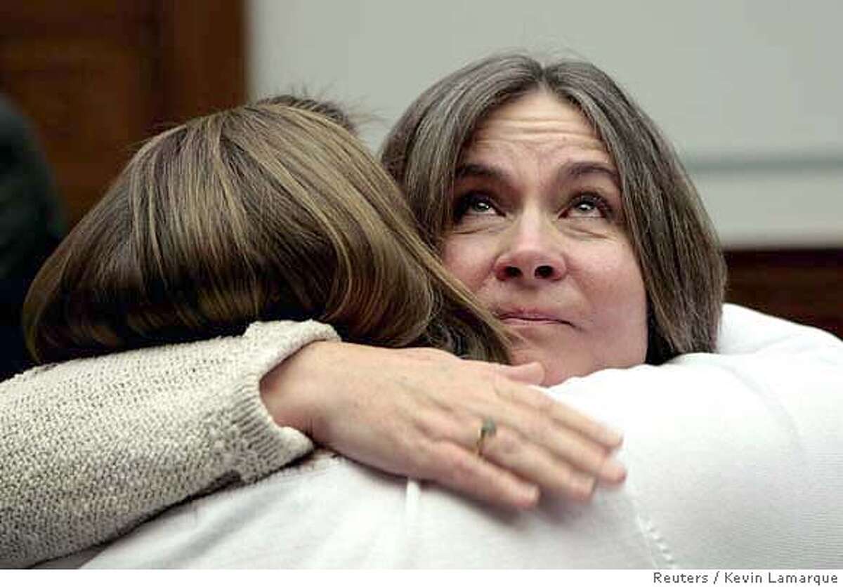 Mary Tillman, mother of former football star Pat Tillman, looks up as she receives a hug after testifying about Pat Tillman's death in battle at a hearing titled "Misleading information from the battlefield" held by the House Oversight and Government Reform Committee on Capitol Hill in Washington April 24, 2007. Tillman is being hugged by another parent at the hearings, Liz Sweet(back to camera), whose son Thomas John Sweet was killed in 2003. Pat Tillman was killed by friendly fire in Afghanistan in 2004. REUTERS/Kevin Lamarque (UNITED STATES) 0