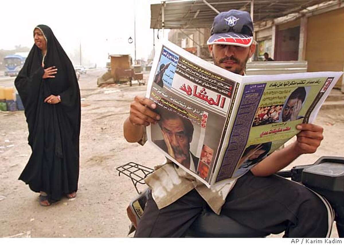 An Iraqi man reads a paper carrying a picture of ousted Iraqi leader Saddam Hussein on its front page in Baghdad, Iraq, Monday Oct. 17, 2005. Saddam Hussein's trial will start on Oct. 19, 2005.(AP Photo/Karim Kadim)