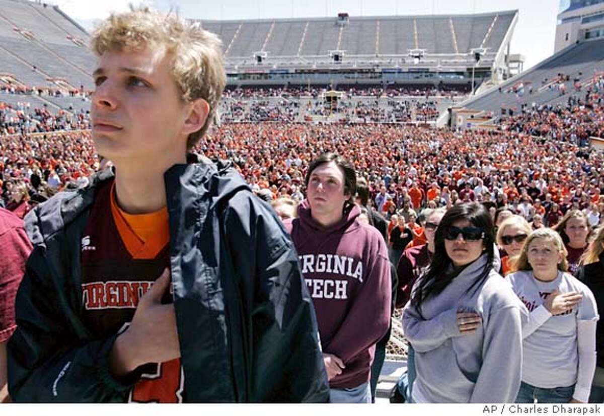 Virginia Tech students, from left to right: Felix Gabathuler, 20, from Lynchburg, Va.; Michael Bell, 20, from Vienna, Va.; Natasha Sheibani, 19, from Great Falls, Va., and Margaret Riggs, 19, from Vienna, Va., stand with thousands of others in an overflow stadium during the convocation memorial attended by President Bush following the shootings on the Virginia Tech campus in Blacksburg, Va., Tuesday, April 17, 2007. (AP Photo/Charles Dharapak)