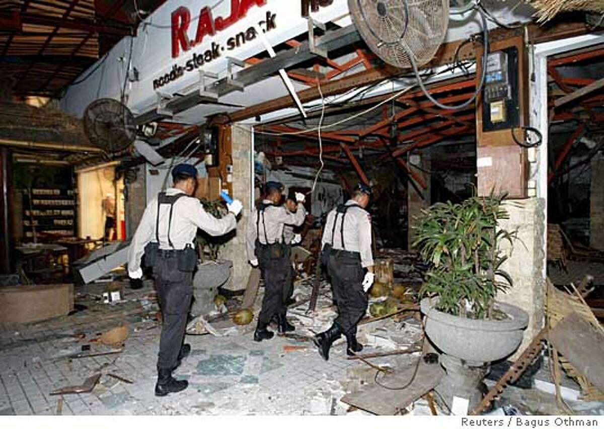Indonesian security officials inspect the scene of an explosion at a restaurant in Kuta, after bomb blasts ripped through popular tourist areas on the Indonesian resort island of Bali October 1, 2005. At least 21 people died and 85 were wounded in bomb blasts in Kuta Square shopping centre and Jimbaran Beach on Bali island on Saturday, officials said. Indonesia's President Susilo Bambang Yudhoyono condemned as terrorism the nearly simultaneous blasts, which come three years after militants linked to al Qaeda bombed two nightclubs in Bali, killing 202 people, mainly foreign tourists. REUTERS/Bagus Othman