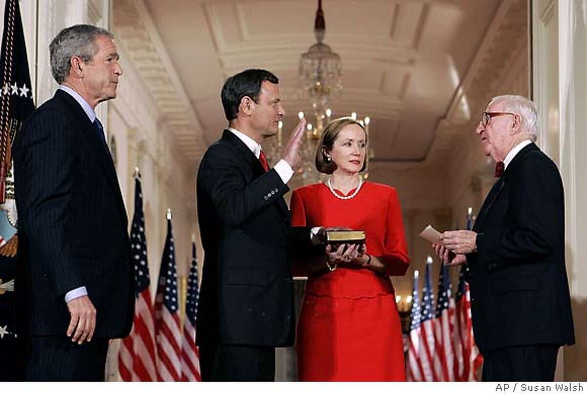 President Bush looks on as John Roberts is sworn in by Justice John Paul Stevens as 17th Chief Justice of the United States in the East Room of the White House, Thursday, Sept. 29, 2005. Roberts' wife Jane holds the Bible. (AP Photo/Susan Walsh)