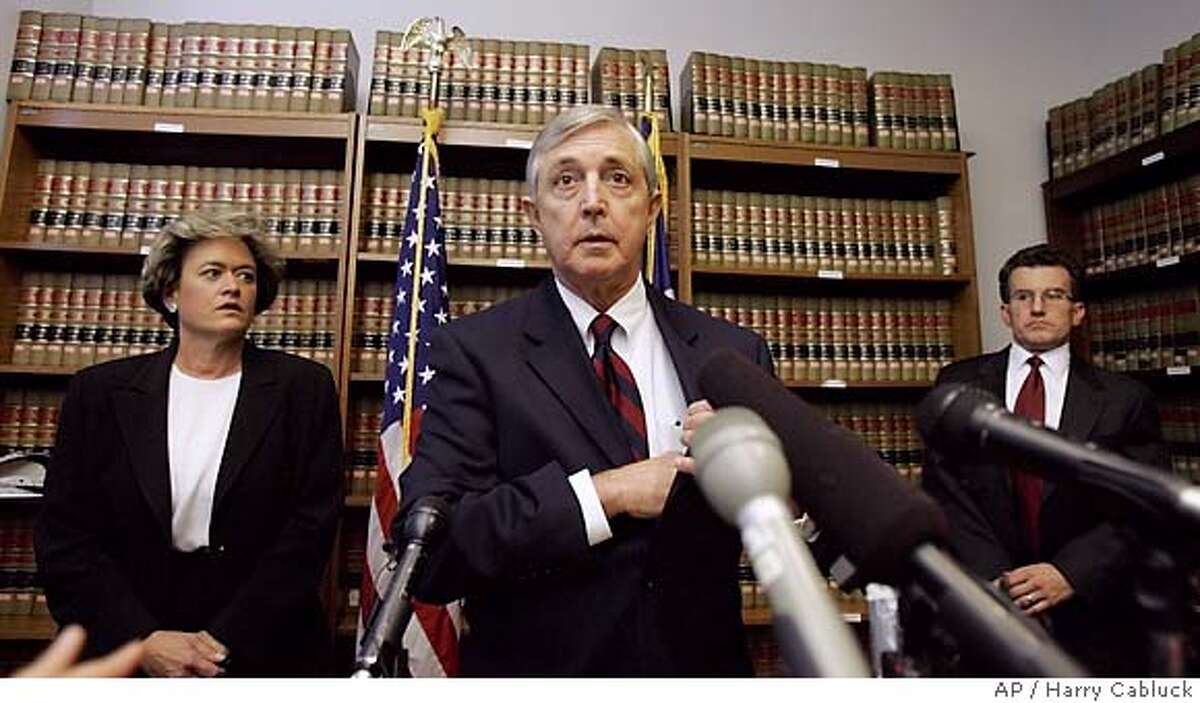 Travis County District Attorney Ronnie Earle, center, prepares to open a news conference after a grand jury on Wednesday, Sept. 28, 2005, in Austin, Texas, charged Rep. Tom DeLay and two political associates with conspiracy in a campaign finance scheme. On the left is Rosemary Lehmberg, first assistant district attorney. On the right is Gregg Cox, head of the Public Integrity Unit. (AP Photo/Harry Cabluck)