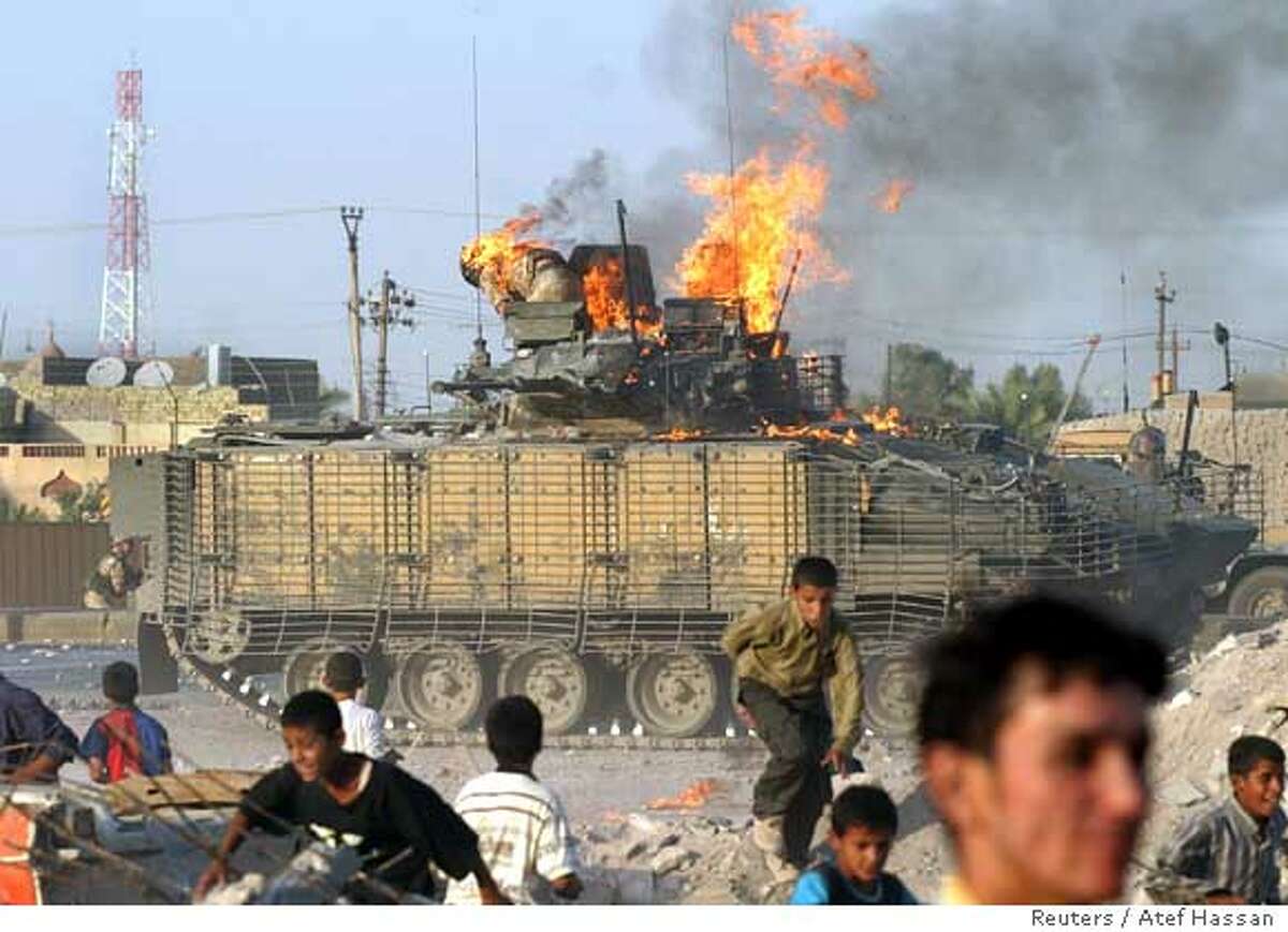 ATTENTION EDITORS - VISUALS COVERAGE OF SCENES OF INJURY OR DEATH A British soldier (background) prepares to jump from a burning tank which was set ablaze after a shooting incident in the southern Iraqi city of Basra September 19, 2005. Angry crowds attacked a British tank with petrol bombs and rocks in Basra on Monday after Iraqi authorities said they had detained two British undercover soldiers in the southern city for firing on police. Two Iraqis were killed in the violence, an Interior Ministry official said. REUTERS/Atef Hassan Ran on: 09-20-2005 A British soldier (background) prepares to jump from a burning armored vehicle in Basra. His injuries reportedly were minor. Ran on: 09-20-2005 A British soldier (background) prepares to jump from a burning armored vehicle in Basra. His injuries reportedly were minor.
