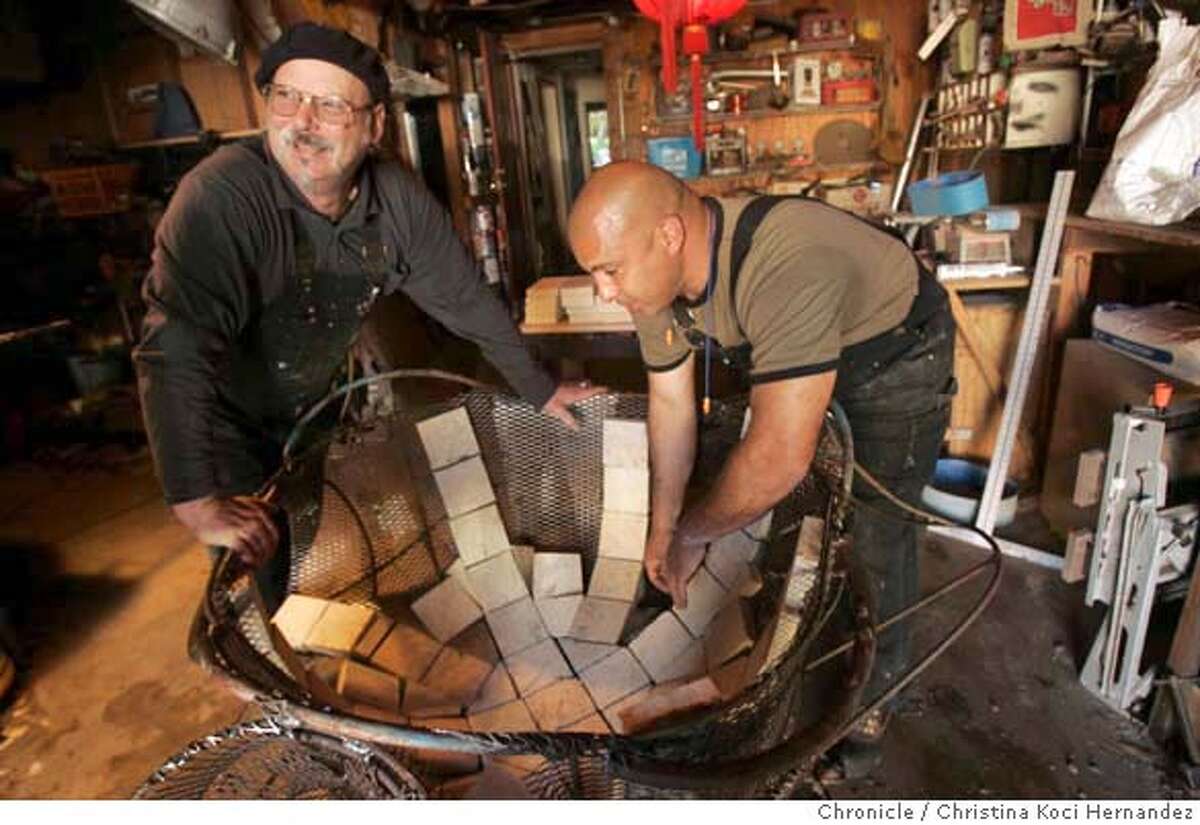 (L) Artist Dan Macchiarini and (R) Moises Luarte work in Macchiarini's studio in San Francisco as he works on two pieces -- "The Wave" and "Clamshell." Golden Gate National Recreation Area is working with Burners Without Burners and Surf Rider to create a dozen artistic fire rings that will be installed on Ocean Beach in an effort to contain the popular beach fires to specific locations. (Christina Koci Hernandez/The Chronicle) CHRONICLE Photos by Christina Koci Hernandez