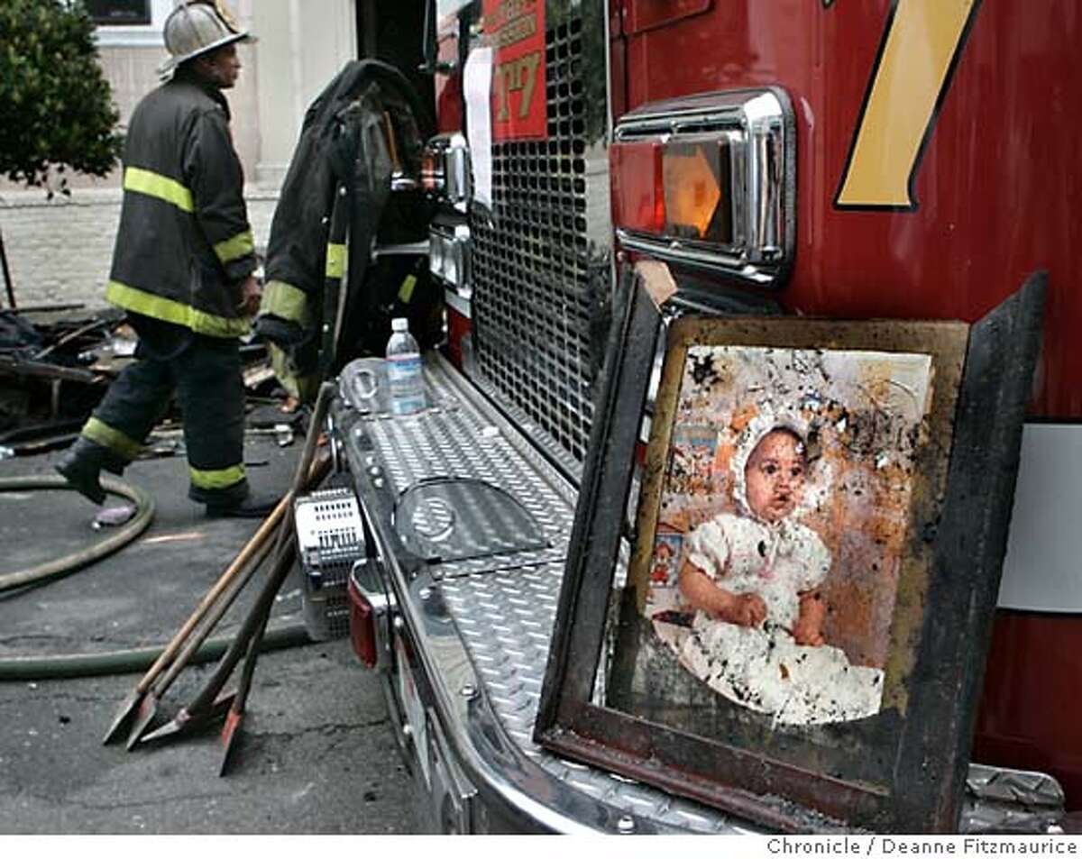 A firefighter found this photo of a baby one of the burned out units. Firefighters are on the scene after an early morning fire on Capp Street in the Mission District. Deanne Fitzmaurice / San Francisco Chronicle