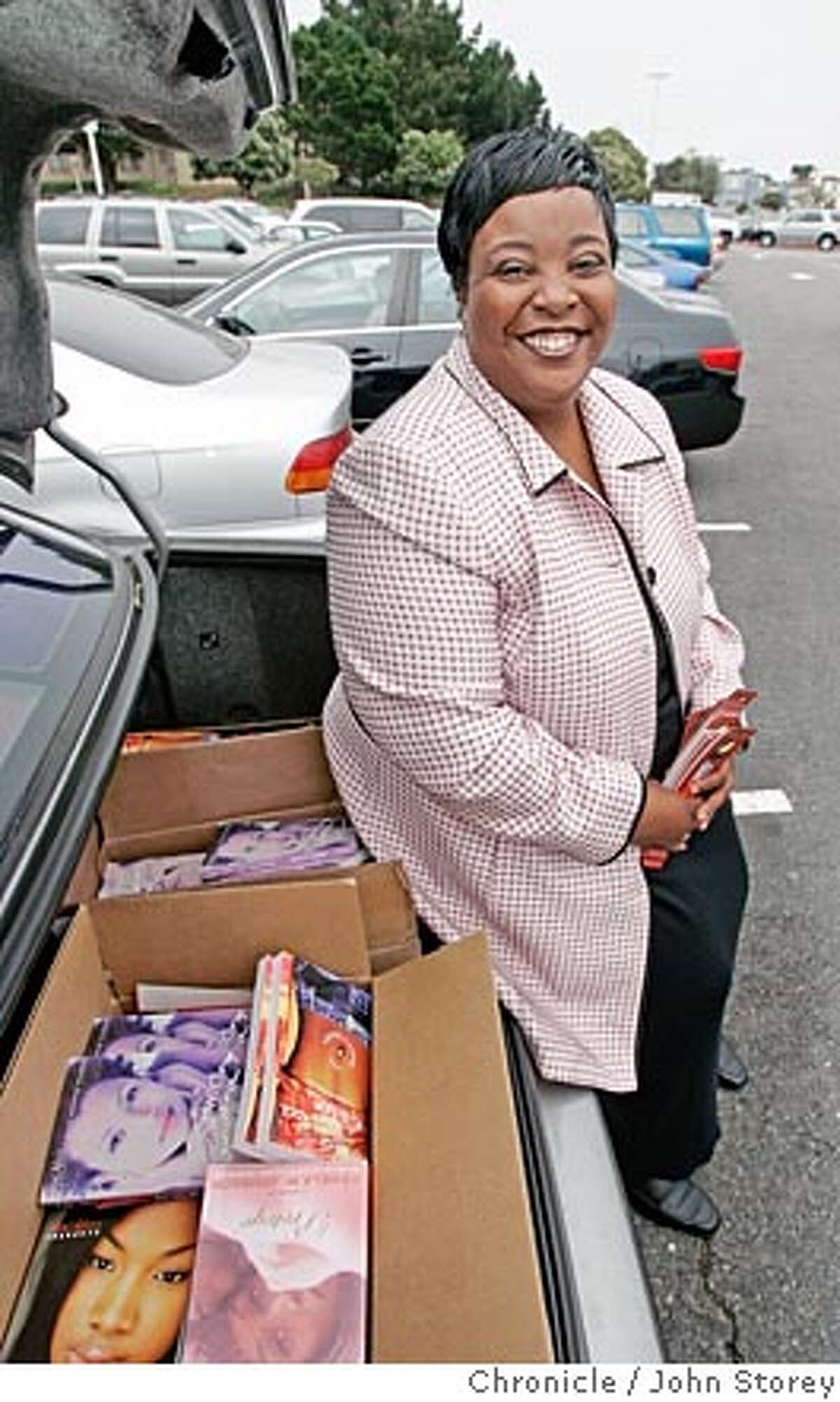 Pamela Johnson sits on the trunk of her BMW where she keeps her books. Author Pamela Johnson sells her books from the truck in her car at Stonestown shopping center and she hands out bookmarks and sells books inside the mall. John Storey San Francisco Event on 9/6/05 -