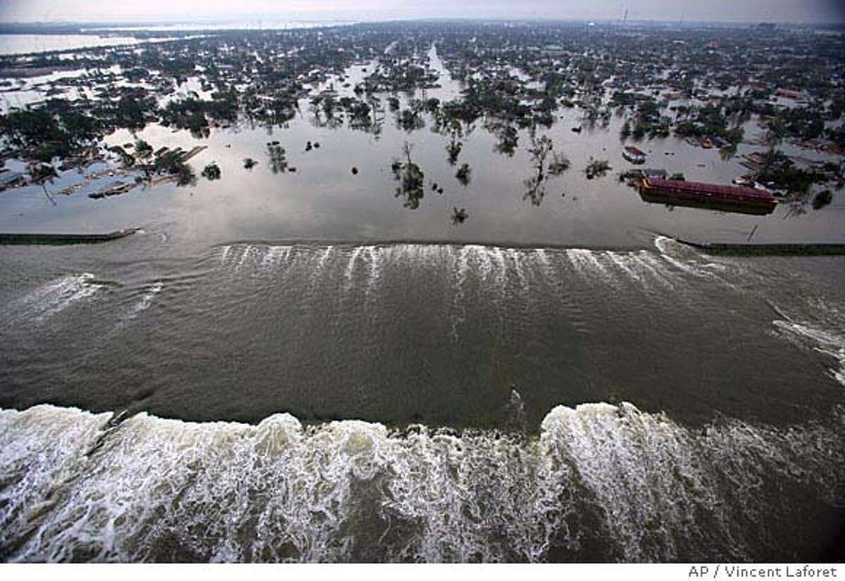 ** ADDS INFORMATION REGARDING FLOODED LEVEE ** Floodwaters from Hurricane Katrina pour through a levee along Inner Harbor Navigaional Canal near downtown New Orleans, La., Tuesday, Aug. 30, 2005, a day after Katrina passed through the city. (AP Photo/Vincent Laforet, Pool) Ran on: 08-31-2005 Surging floodwaters pour through a wide breach in the levee along the Industrial Canal near downtown New Orleans. ADDS INFORMATION REGARDING FLOODED LEVEE POOL PHOTO