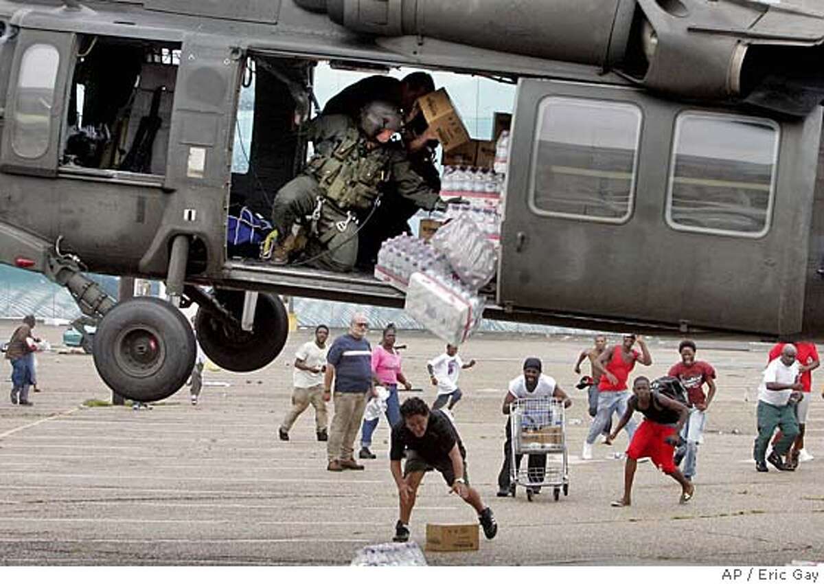 A military helicopter makes a food and water drop to survivors of Hurricane Katrina near the Convention Center in New Orleans, Thursday, Sept. 1, 2005. (AP Photo/Eric Gay) RETRANSMISSION TO PROVIDE ALTERNATE CROP
