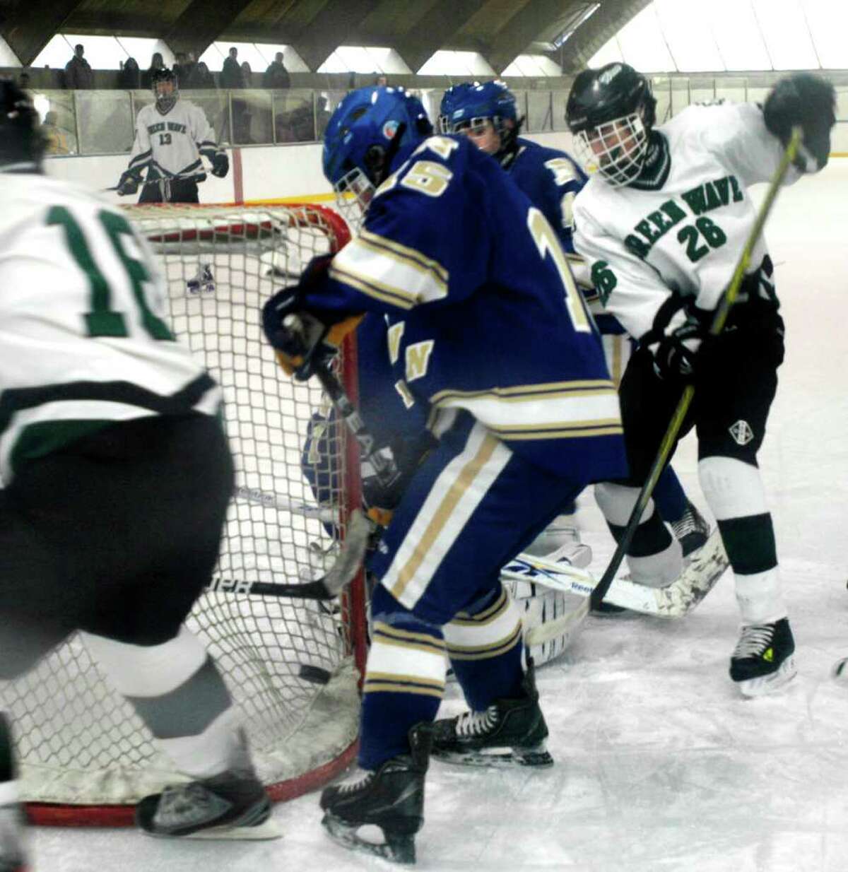 SPECTRUM/The Green Wave's Cody Paquin (26) tries to jam the puck into the net, but the Nighthawk 'D' manages to deflect it just wide as New Milford High School ice hockey team takes on Newtown, Jan. 14, 2012 at South Kent School. Holding his position behind the net is NMHS' Chad Fasig.