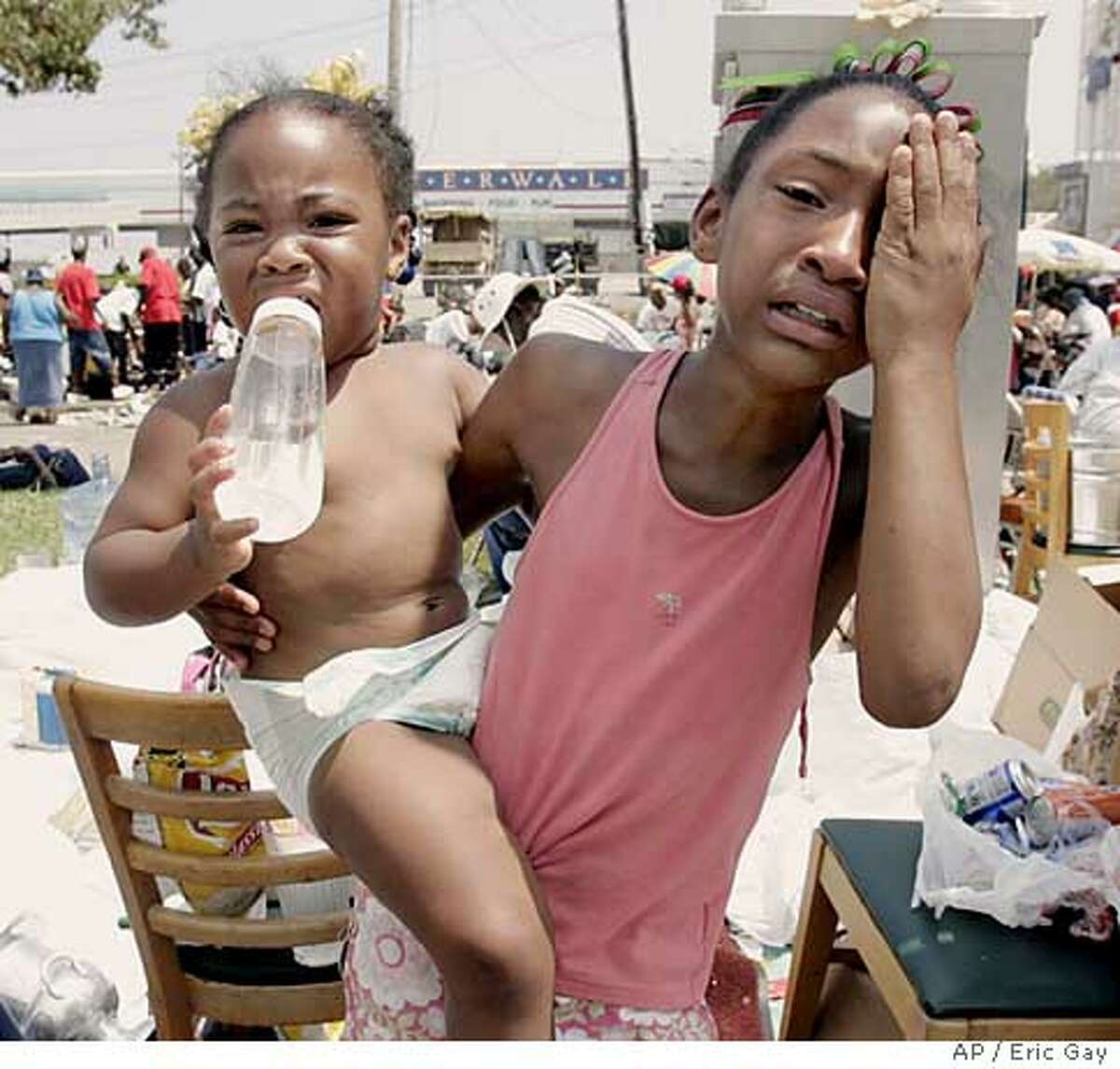 Terri Dorsey, 10, and Imari Clark, 1, reacts after as a family member is treated for heat exhaustion where they have been waiting for days to be evacuated from the convention center in New Orleans, La., Friday, Sept. 2, 2005. (AP Photo/Eric Gay)
