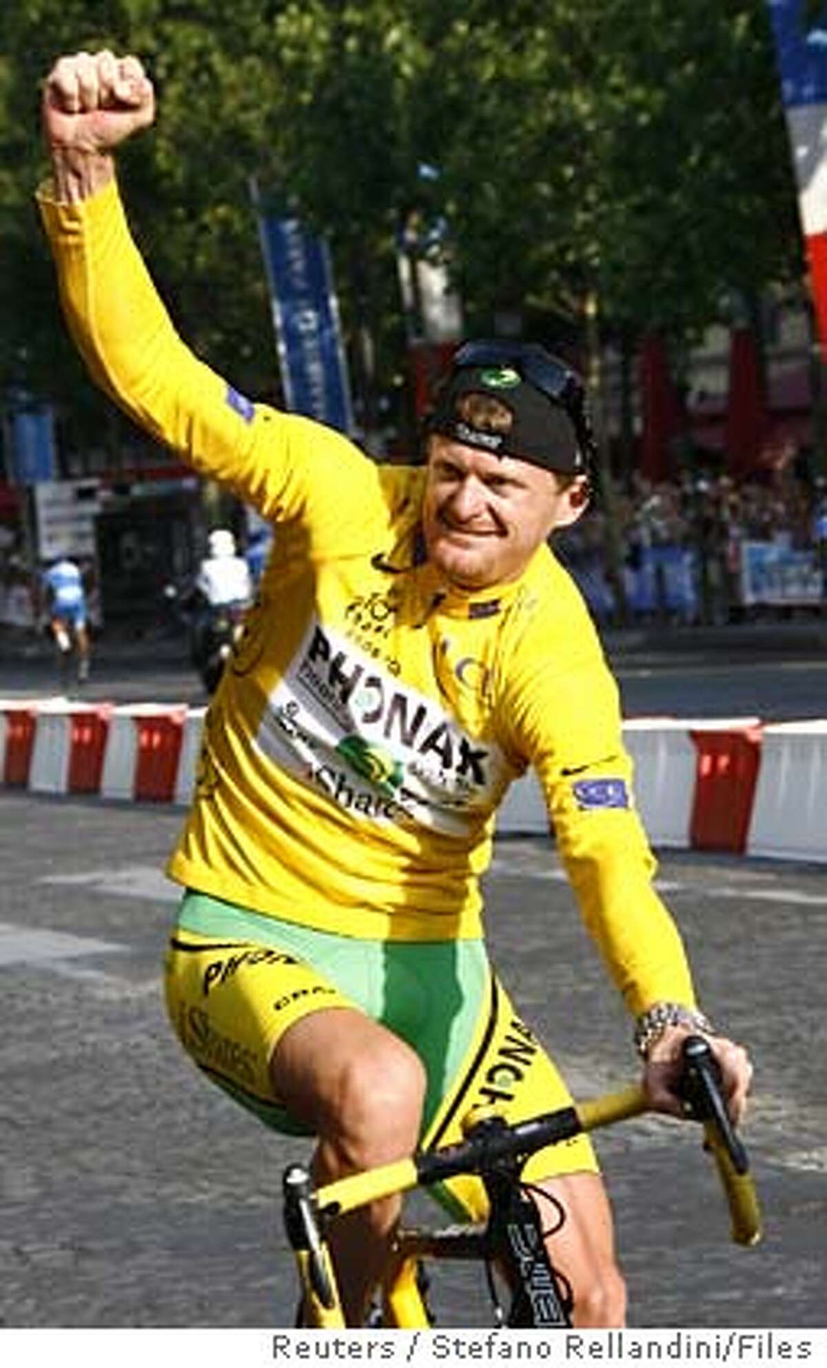 Phonak's team rider Floyd Landis of the U.S., wearing the leader's yellow jersey, celebrates as he takes his lap of honour around the Champs Elysees after winning the 93rd Tour de France cycling race in Paris in this July 23, 2006 file photo. Landis is likely to lose his Tour de France title after a second drugs sample on Saturday confirmed a positive test for excessive amounts of the male sex hormone testosterone. REUTERS/Stefano Rellandini/Files (FRANCE) Ran on: 08-13-2006 Floyd Landis, the U.S. rider on the Phonak team shown taking his lap of honor in Paris last month after winning the Tour de France, has failed two drug tests.