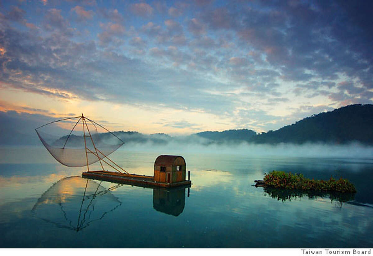 TRAVEL TAIWAN -- A fishing raft floats on ethereal Sun Moon Lake in Taiwan. credit: Taiwan Tourism Board