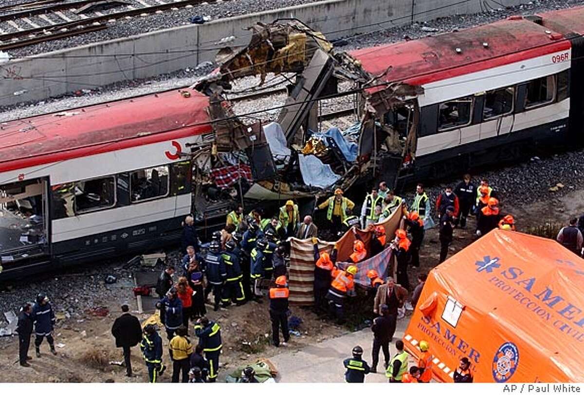 ** FILE ** Rescue workers cover up bodies alongside a bomb-damaged passenger train, following a number of explosions in Madrid, Spain, in this March 11, 2004 file photo, killing more than 170 rush-hour commuters and wounding more than 500 in Spain's worst terrorist attack ever. An Al-Qaida-linked group that claimed responsibility for the Madrid train bombings warned European nations that they have only two weeks to withdraw troops from Iraq or face the consequences, a pan-Arab newspaper reported Friday, July 2, 2004. (AP Photo/Paul White) Ran on: 07-18-2004 MARCH 11, 2004 FILE PHOTO
