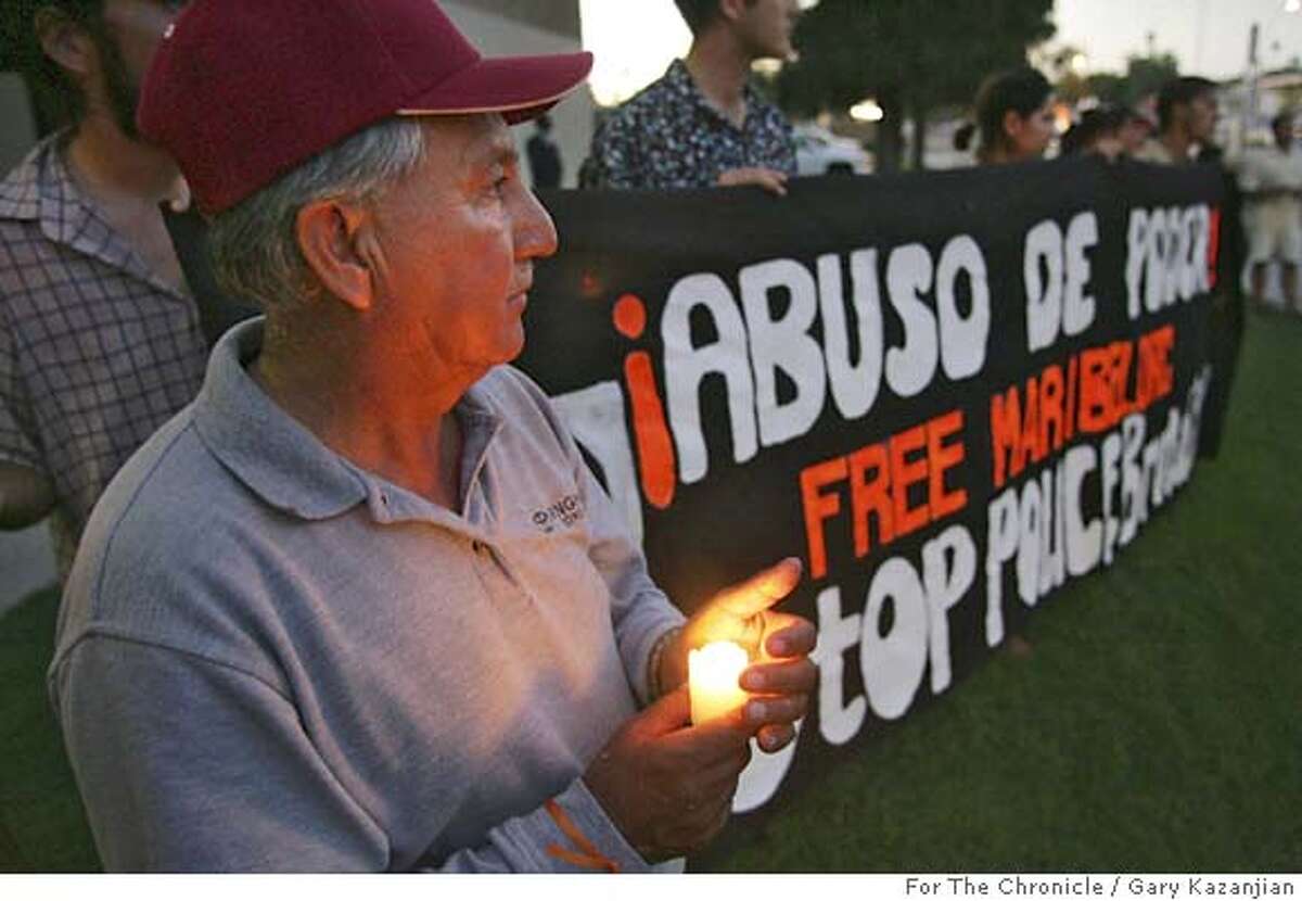 Miguel Fonseca holds a candle during a vigil in support of Cuevas with a Free sign behind him Friday, June 29, 2005 in Fresno, Calif. 11-year-old Cuevas faces a felony assault charge for throwing a rock at a boy and hitting him in the head after waterballoons were thrown at her. Cuevas spent several days in juvenile hall when police arrested her, soon after the ambulance the family had called arrived.(GARY KAZANJIAN/FOR THE CHRONICLE)